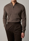 Cosmo quarter-zip jumper in brown, worn on a model with hand in pocket