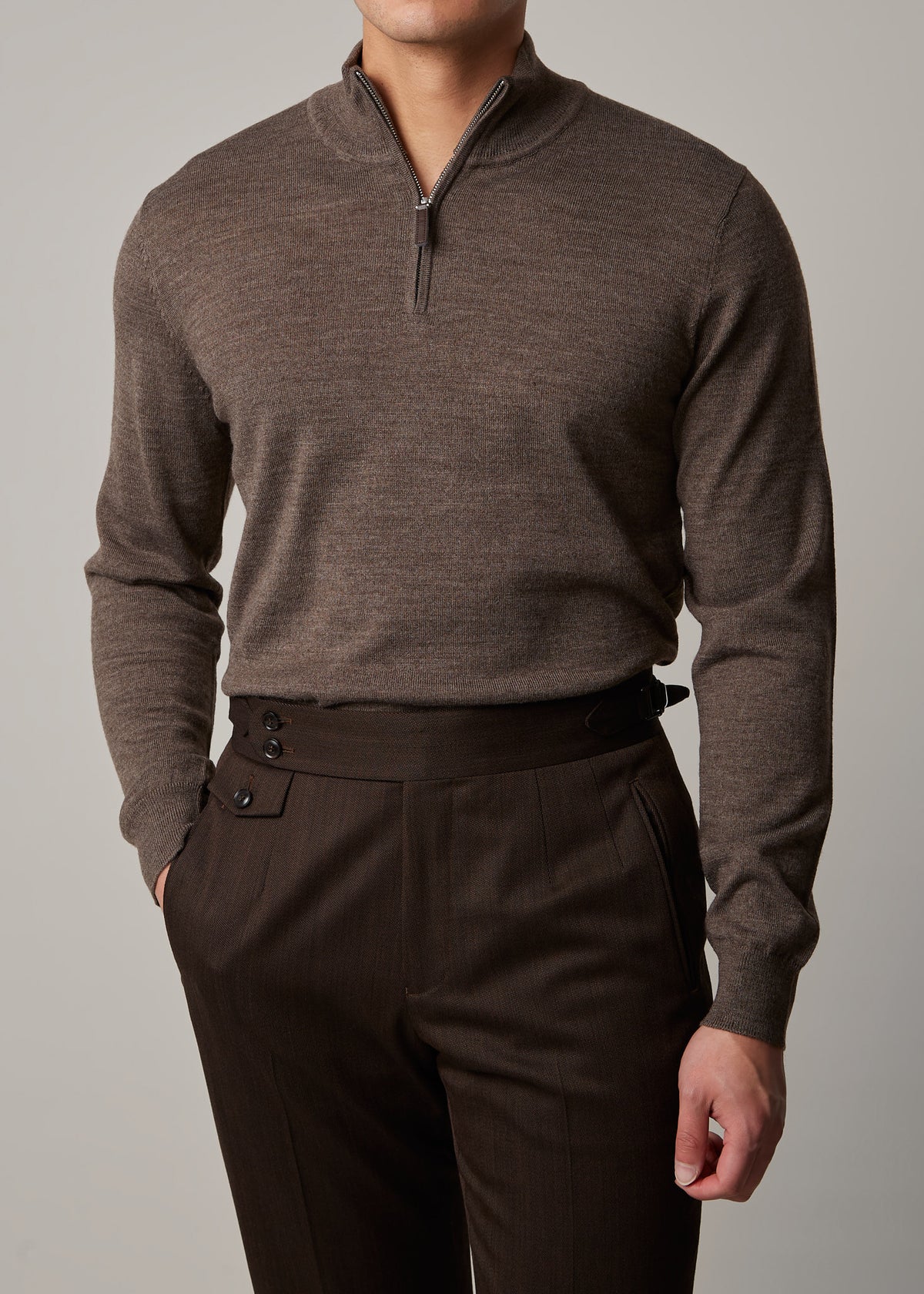 Cosmo quarter-zip jumper in brown, worn on a model with hand in pocket