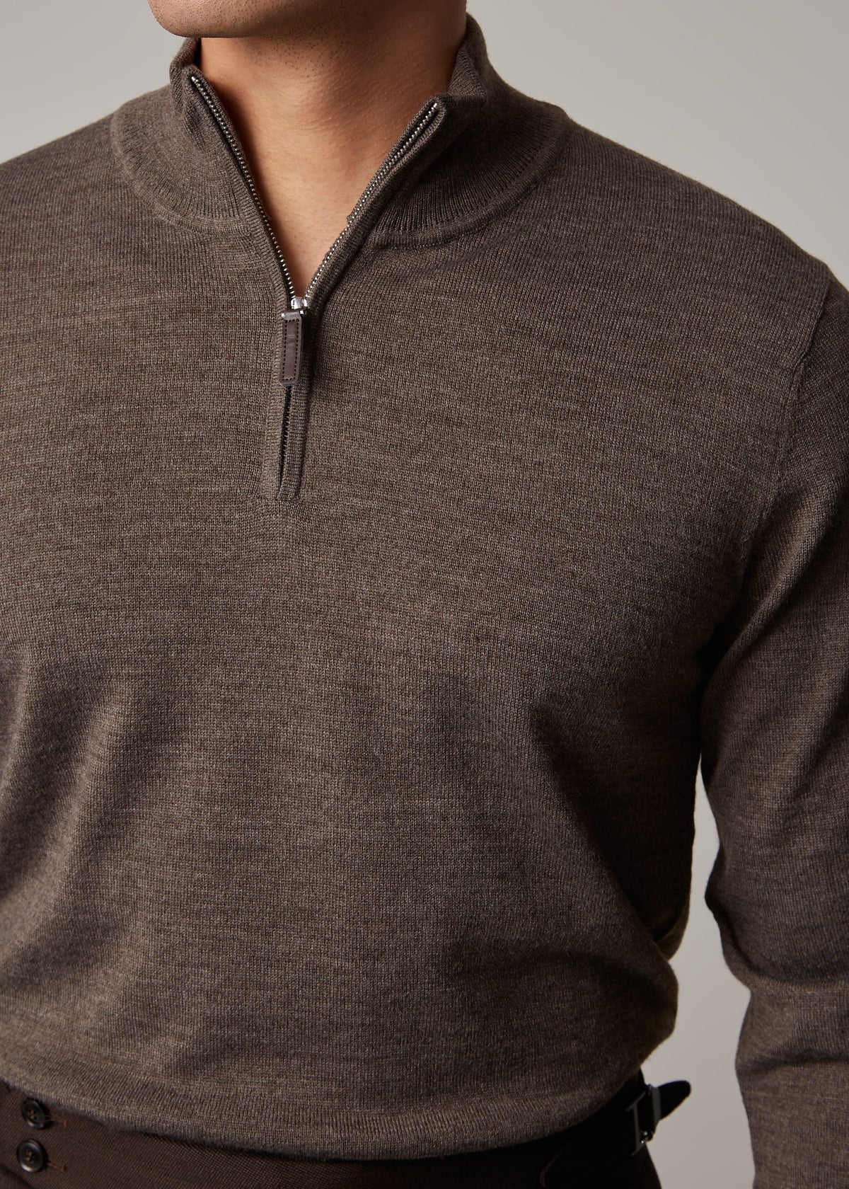 Close-up of the brown Cosmo jumper's zip, cropped to show the waistband