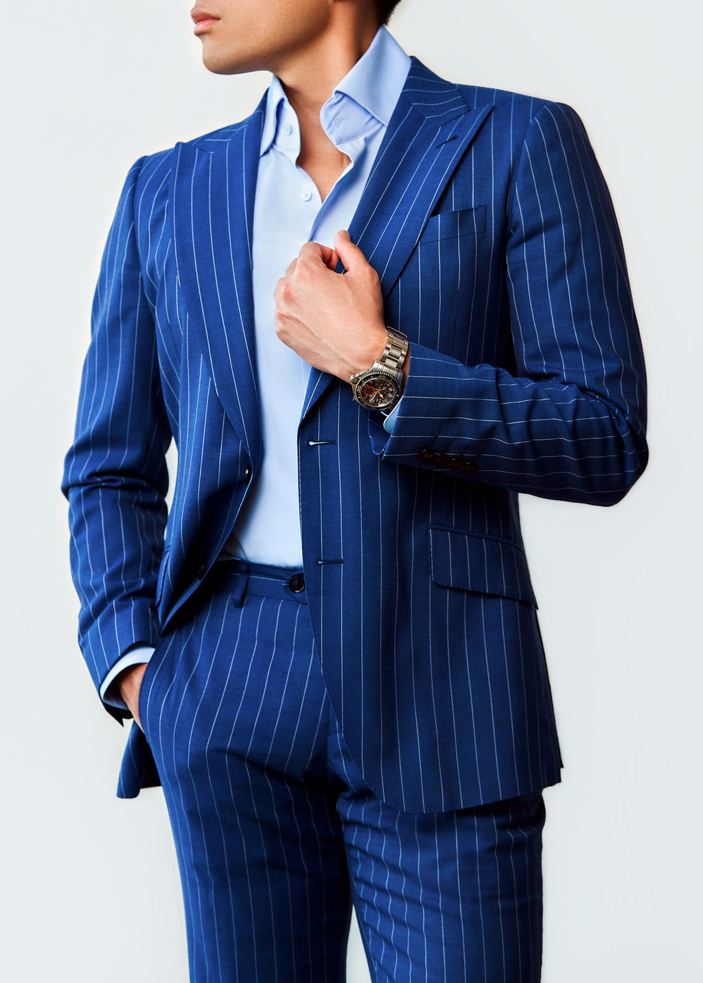 Sussex Blue Pinstripe Suit, angled view of a model with hand on the lapel