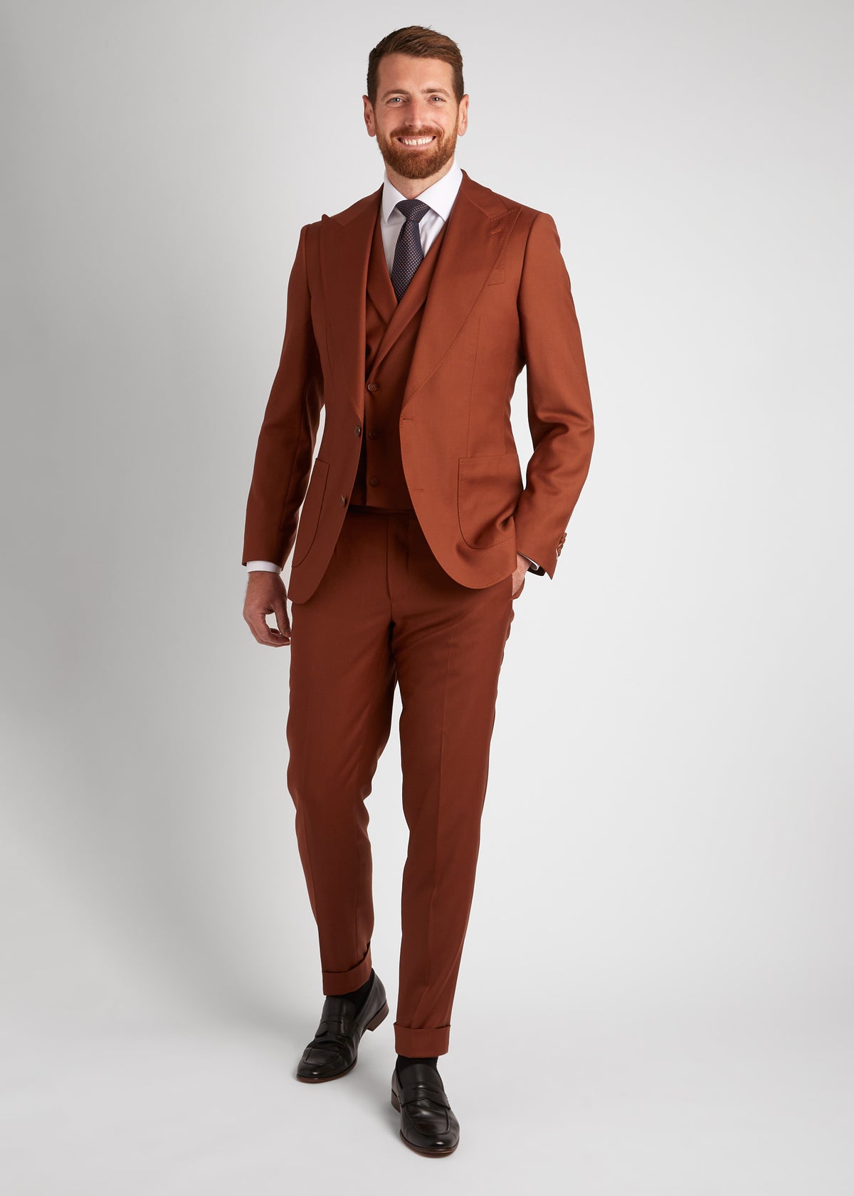 Birmingham Tobacco Brown Suit, standing with a hand in the pocket, smiling