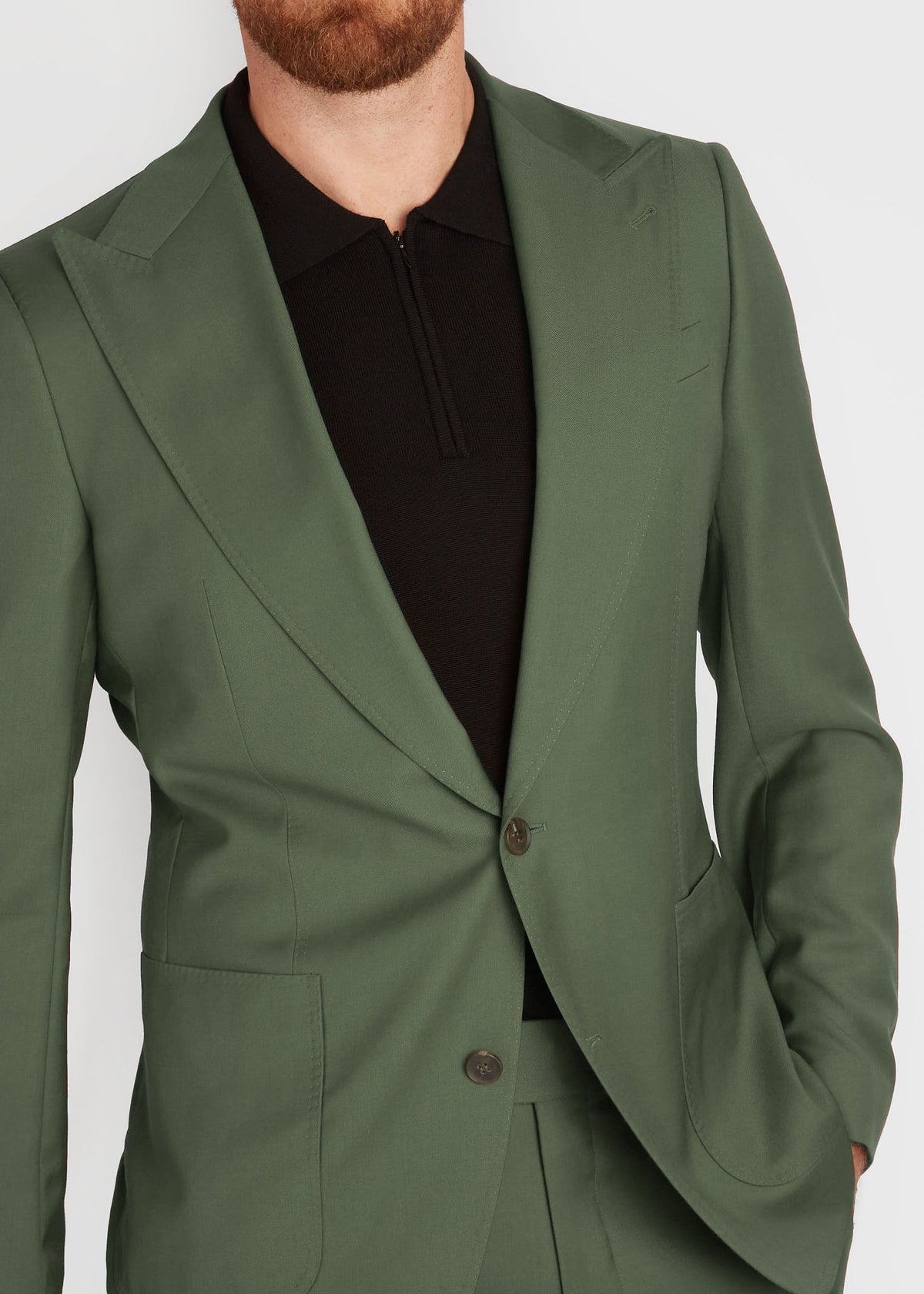 Darling Point Green Suit jacket open over a black zip-neck top, close-up