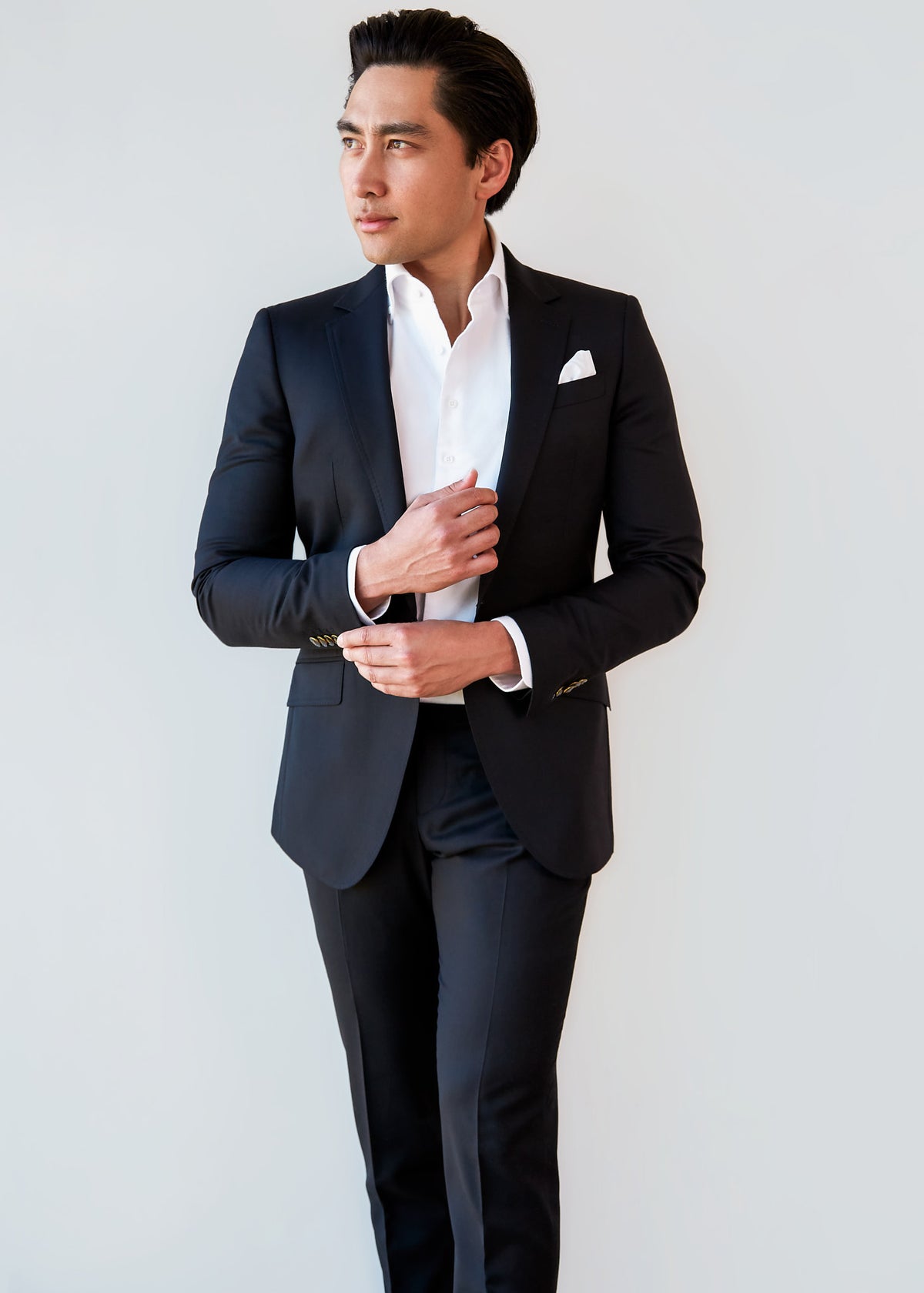 High Street Classic Black Suit on a model, side profile adjusting the cuff