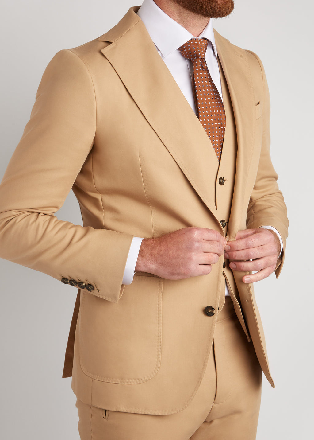 Berkeley Beige Suit, close-up of the lapel as a model fastens the jacket