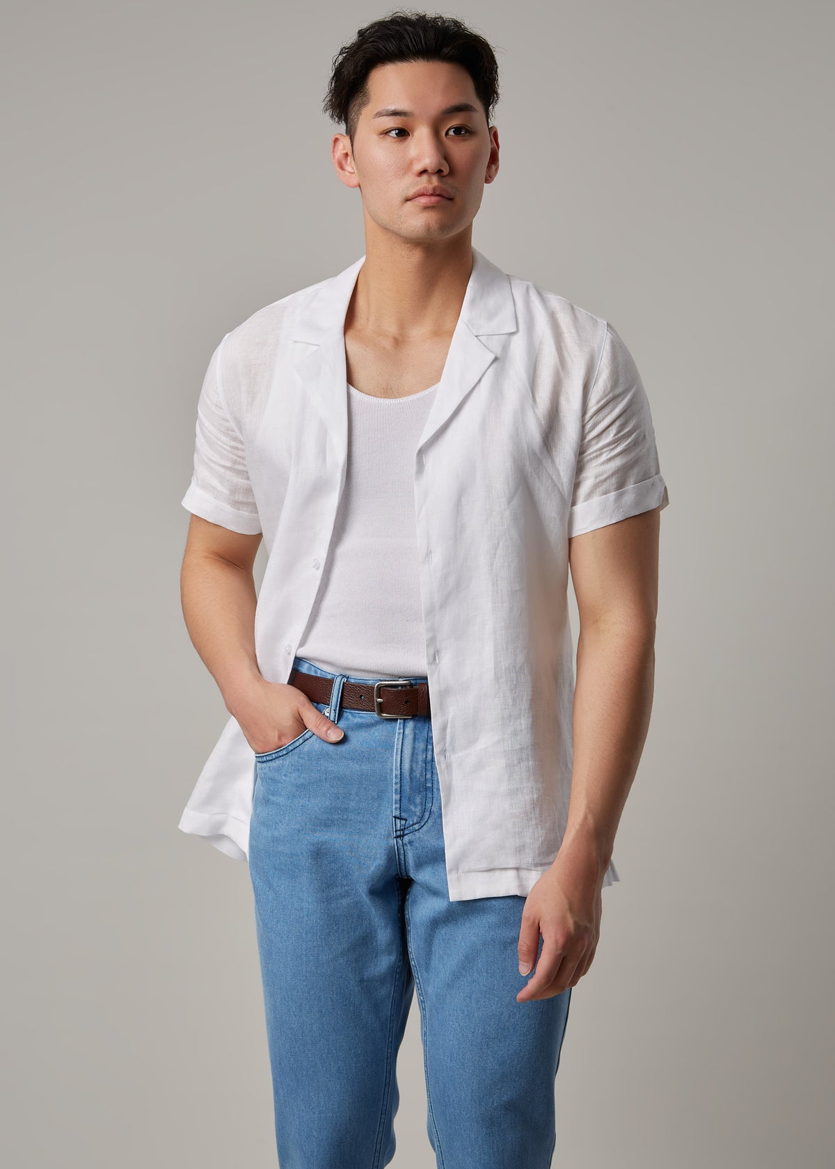 Light Blue Denim Jeans worn with an open white shirt on a model, hand in pocket