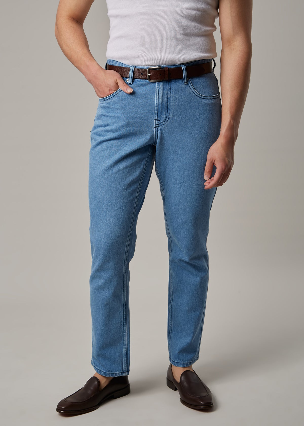 Light Blue Denim Jeans worn with a tank top and brown belt on a model