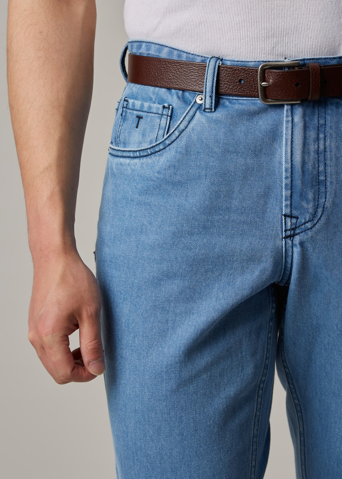 Light Blue Denim Jeans, close-up of the front pocket and belt buckle