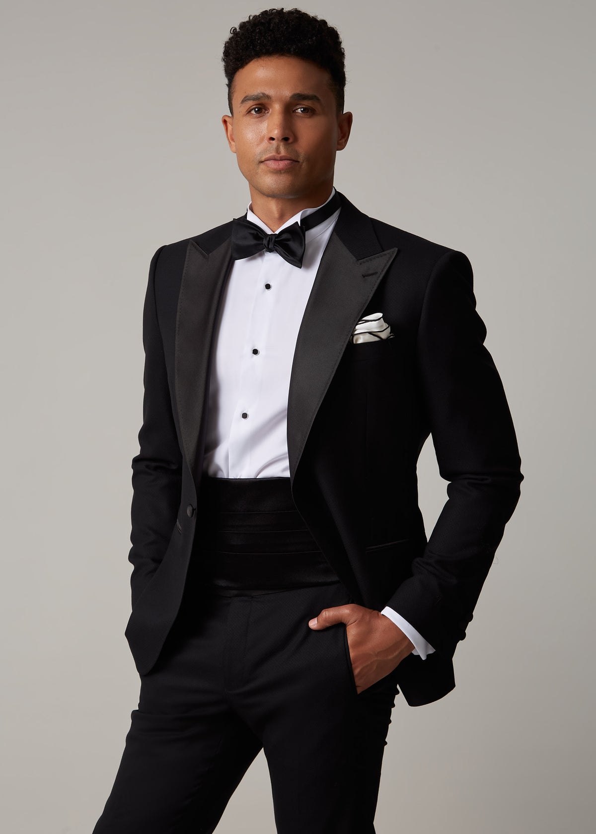 The Great Black Tuxedo with cummerbund, front view with hand resting near pocket