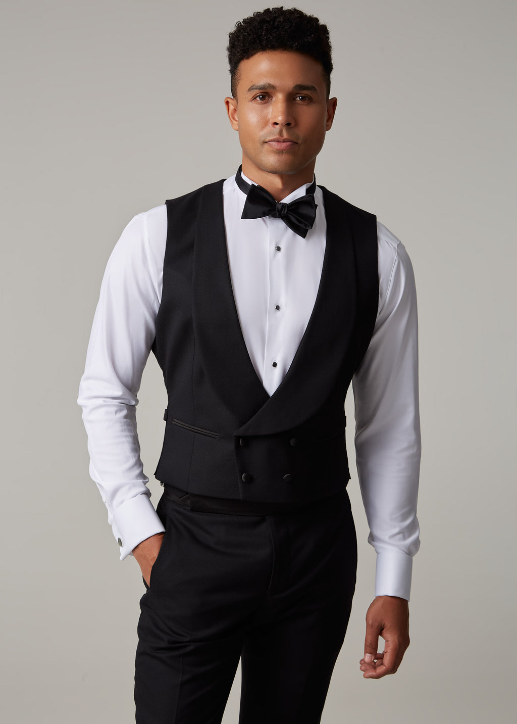 The Great Black Tuxedo waistcoat in shirtsleeves, full front view with hand in pocket