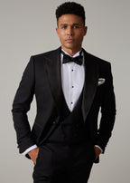 The Great Black Tuxedo jacket open over waistcoat, front view from the waist up with hands in pockets