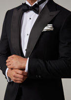 Close-up of The Great Black Tuxedo jacket cuff and sleeve with hands adjusting cuff