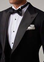 Close-up of The Great Black Tuxedo satin peak lapel, bow tie and pocket square