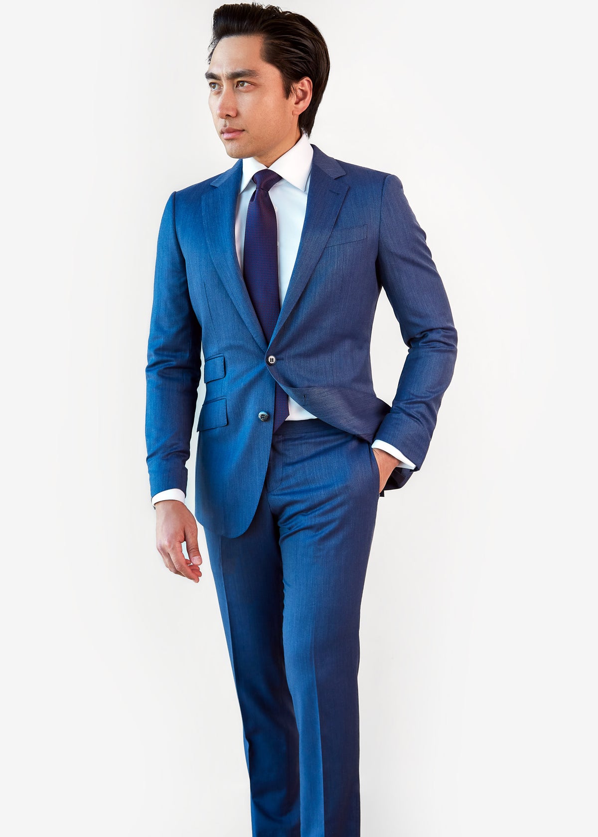 Tokyo Tie in blue micro pattern worn with a blue suit, styled on a model