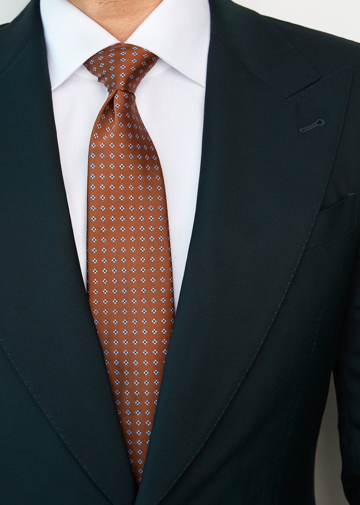 Close-up of the Seoul Tie knot styled with a dark green suit and white shirt