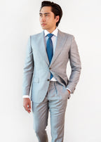 Tulum Tie in a blue pattern styled with a light grey suit on a model