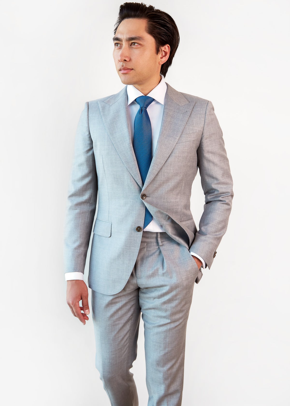 Tulum Tie in a blue pattern styled with a light grey suit on a model