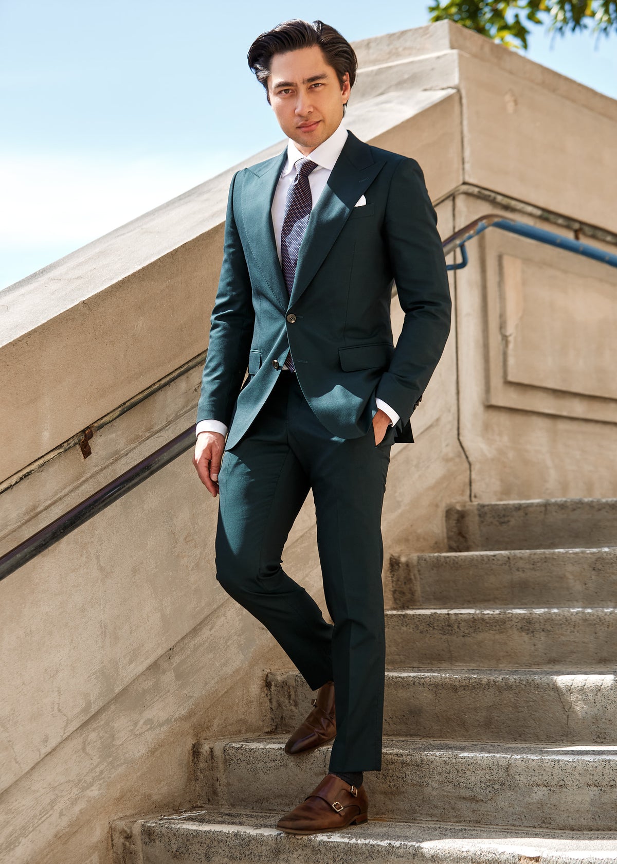 Chicago Tie styled with a dark green suit on a model, outdoors on stone steps