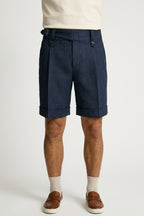 The Byron Navy Wool-Blend Double-Pleat Shorts, front view on a model styled with a cream tee, white socks and tan penny loafers