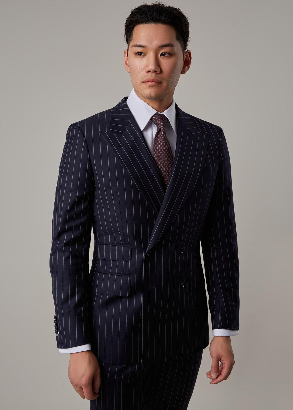 Greenwich Pinstripe Suit double-breasted jacket, close crop from the chest with tie visible