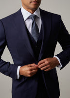 Close-up of a model's hands buttoning the Rialto Royale Navy Suit jacket