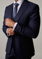 Rialto Royale Navy Suit worn with hands clasped at the cuff, tie and waistcoat visible