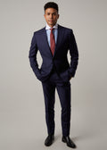 Rialto Royale Navy Suit worn with a rust tie and striped shirt, hands in pockets