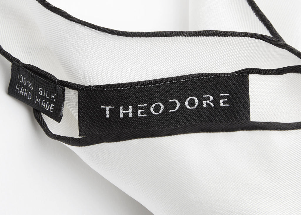 Lyon Pocket Square in white silk, close-up of the woven Theodore label