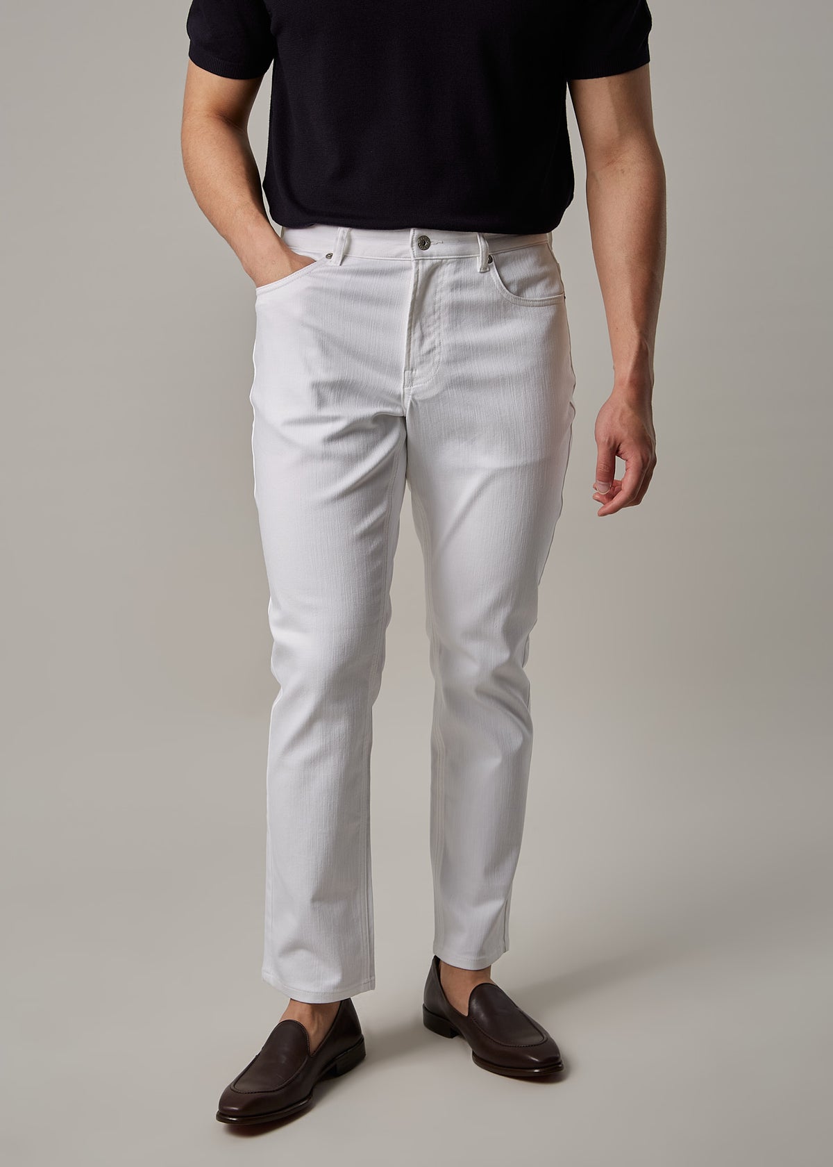 White Denim Jeans worn with a dark polo on a model, front view