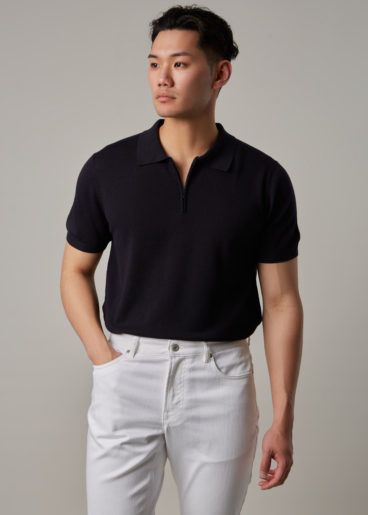White Denim Jeans worn with a dark zip polo on a model, torso view