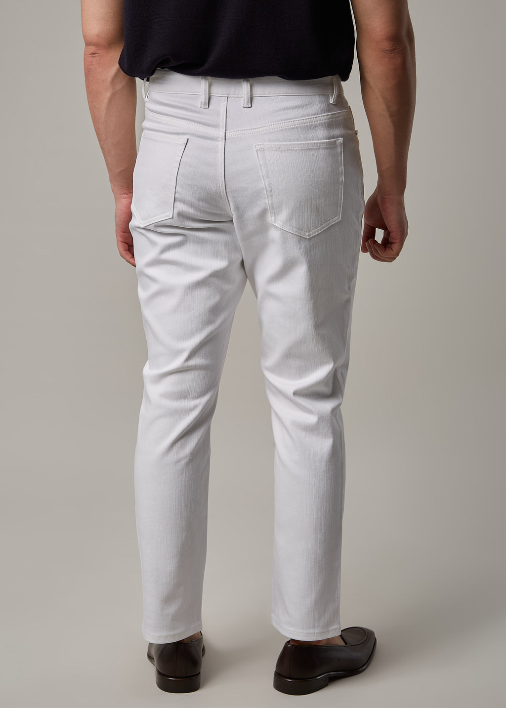 White Denim Jeans, full back view on a model wearing a dark polo