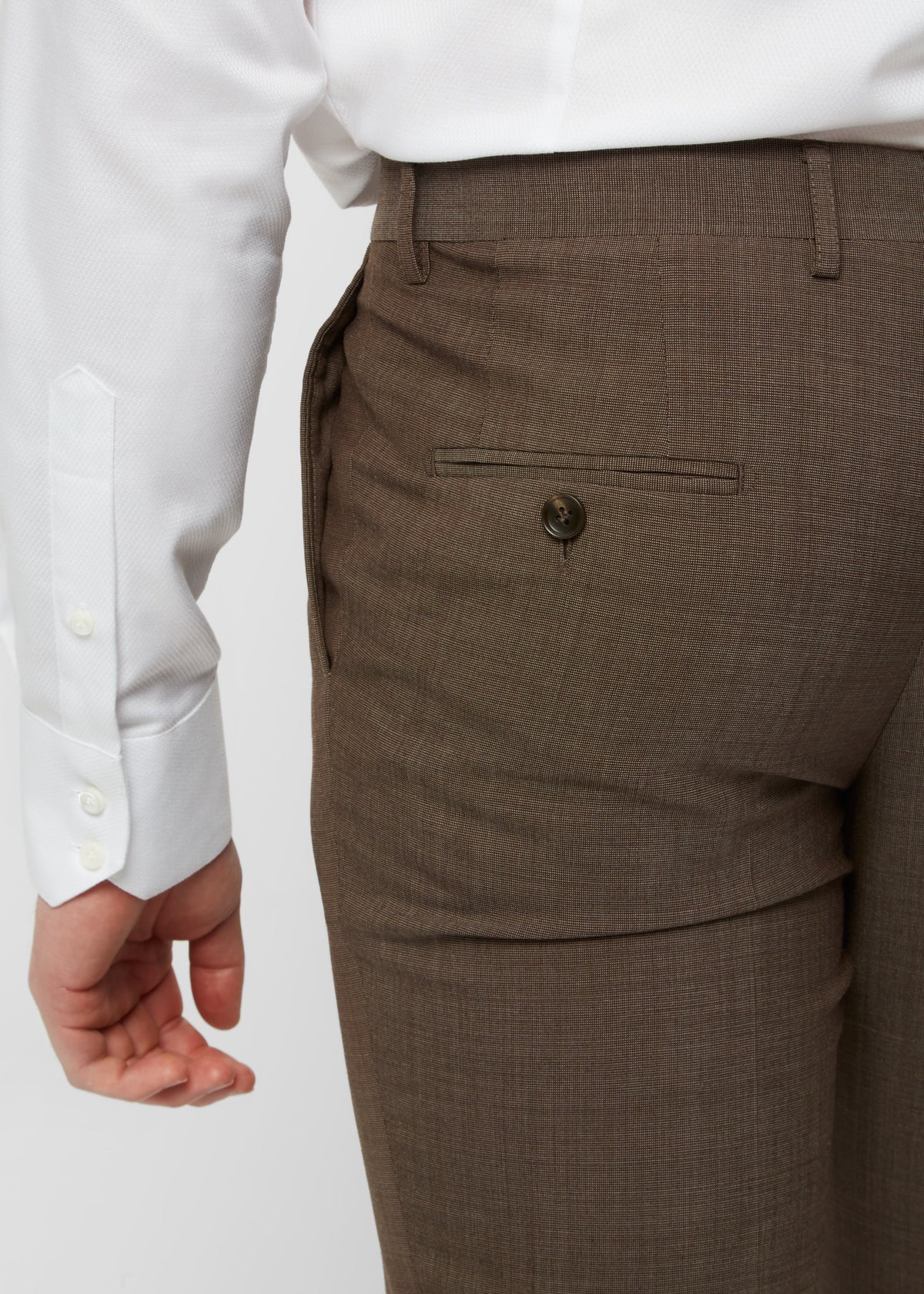 Close-up of the Madison Avenue Brown Suit trouser back pocket, hand nearby