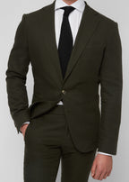 Greenwich Village Olive Suit close-up on a model with hand in pocket and knit tie