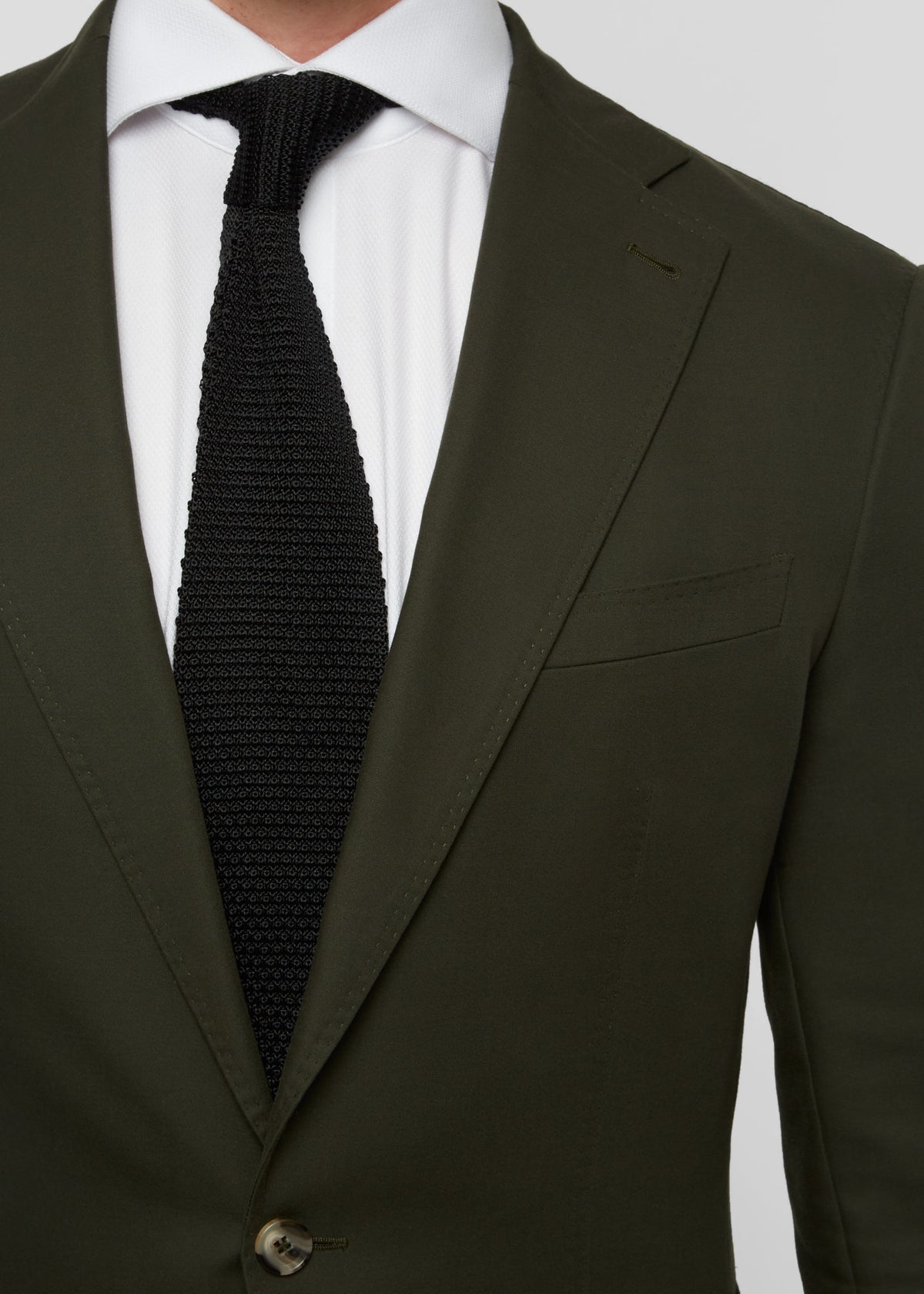 Greenwich Village Olive Suit close-up of lapel, button and tie centred on chest
