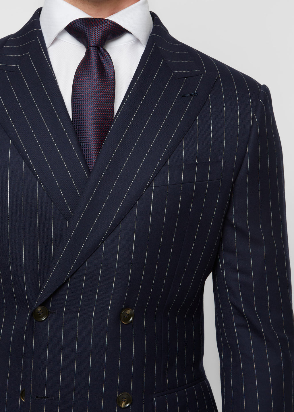 Close-up of the Savile Row Navy Pinstripe Suit button stance, hand in pocket
