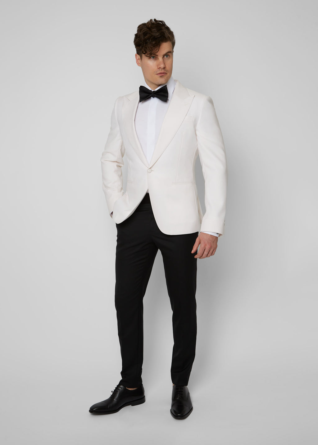 Opera House Off White Tuxedo on a model, full front view with a black bow tie