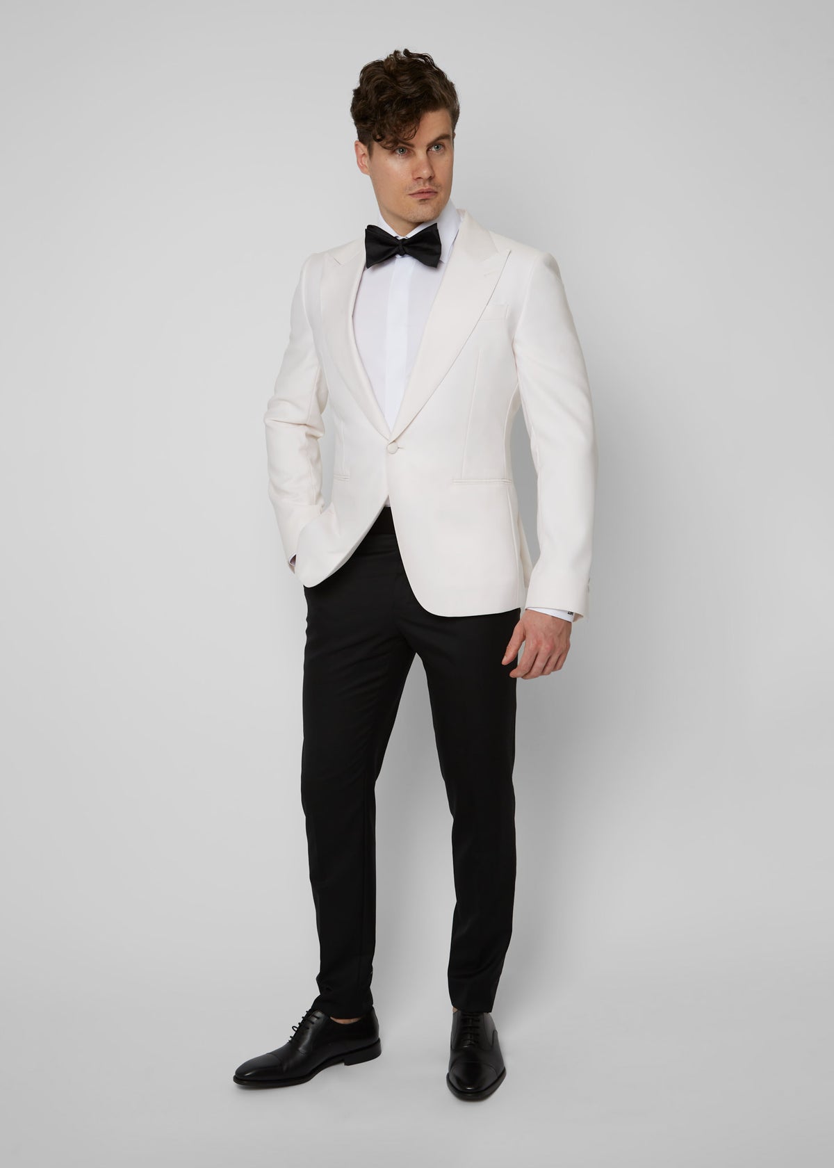 Opera House Off White Tuxedo on a model, full front view with a black bow tie