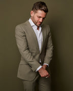 Devonshire Olive Suit jacket open over a white shirt, front view, model looking down
