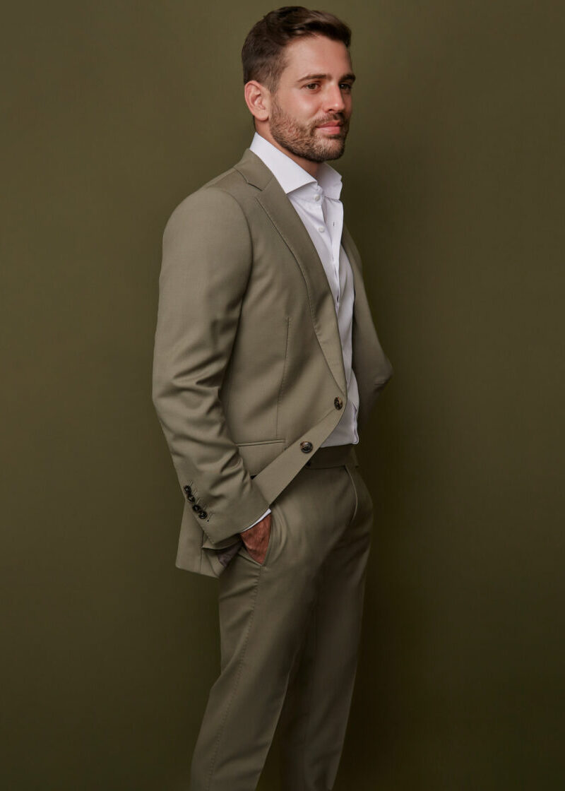 Devonshire Olive Suit jacket worn open over a white shirt, side profile on a model
