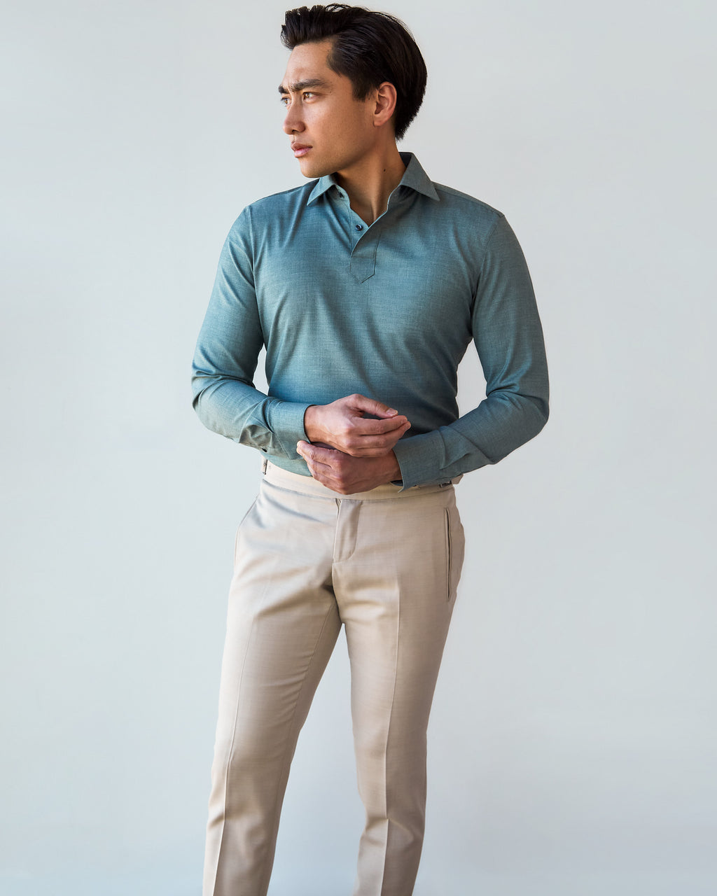 Green Popover Shirt, front view with hands clasped and a model looking aside