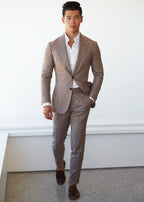 Ivory popover shirt worn under a tan suit on a model, full-length walking shot
