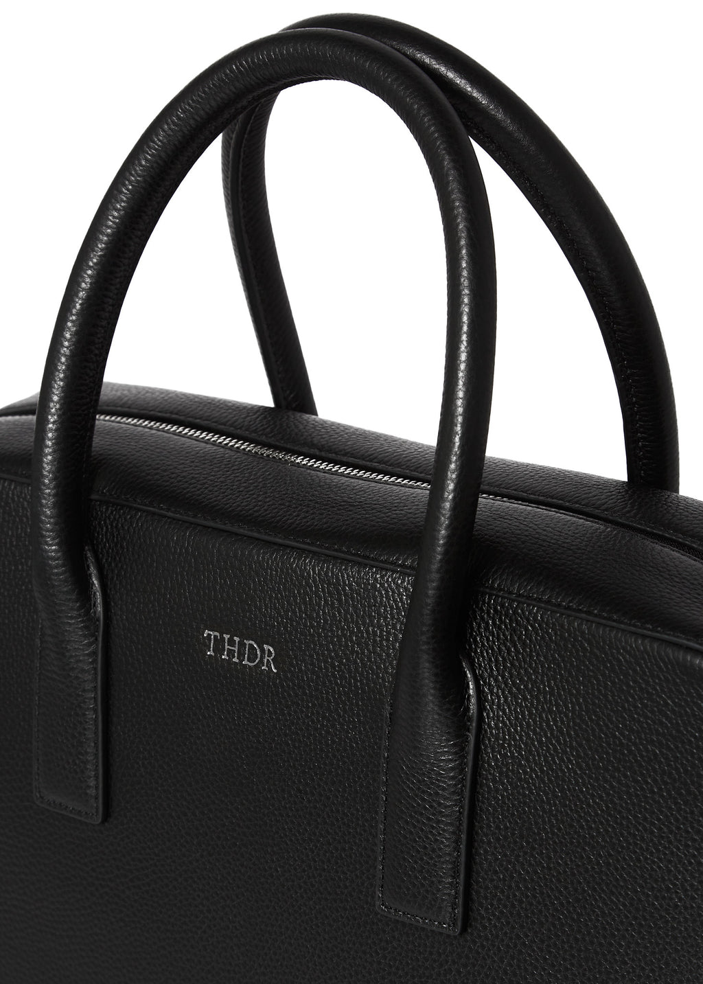 Close-up of the Timothy briefcase handles and embossed THDR logo