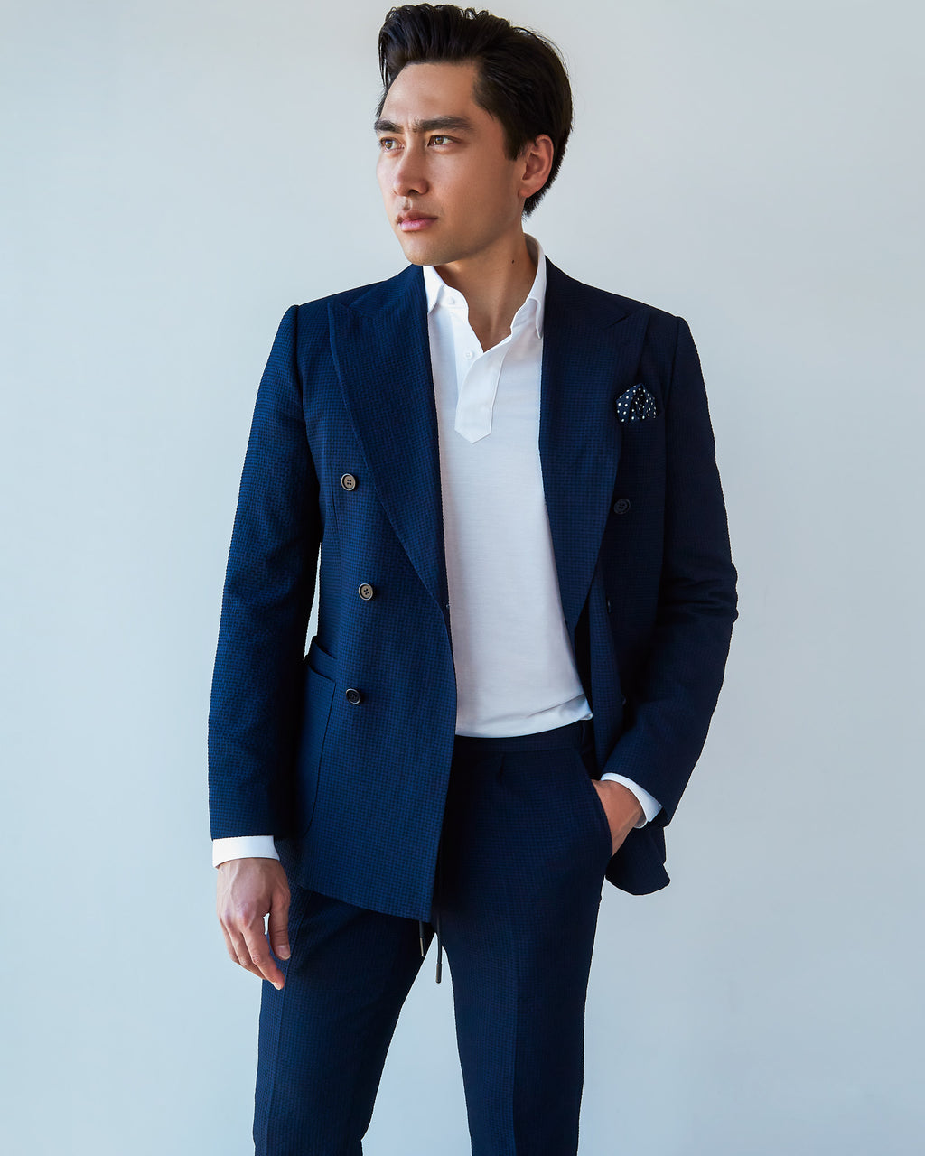 White Popover Shirt layered under an open navy double-breasted blazer with a pocket square