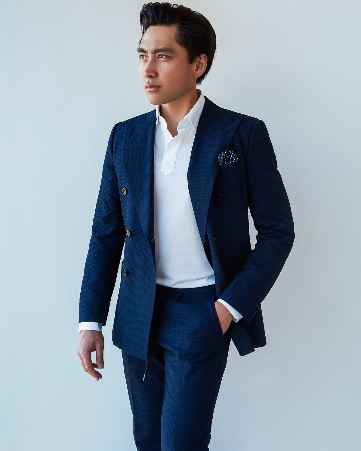 White Popover Shirt under the navy blazer, a model glancing aside at a slight angle
