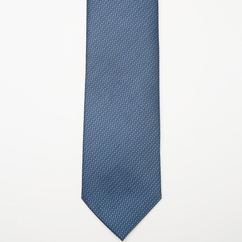 Tulum Tie in a blue pattern laid flat on a plain background