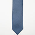 Tulum Tie in a blue pattern laid flat on a plain background