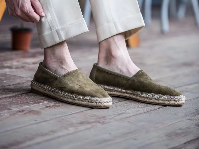 Aries Olive Handcrafted Woven Fisherman Shoes worn on a model on a wooden deck
