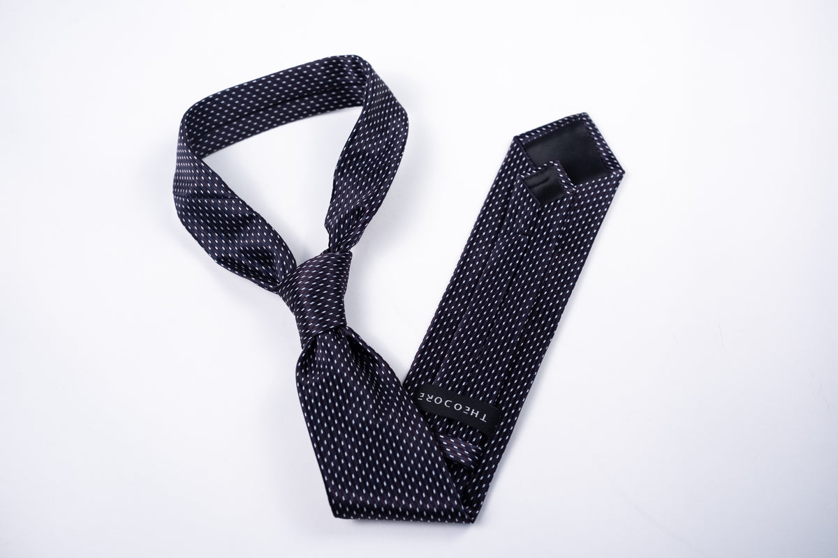 Berlin Tie - Black Micro Dot, shown tied and flat with keeper label