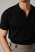 Fireball Zip Polo Black on a model, wider view showing the trouser waistband