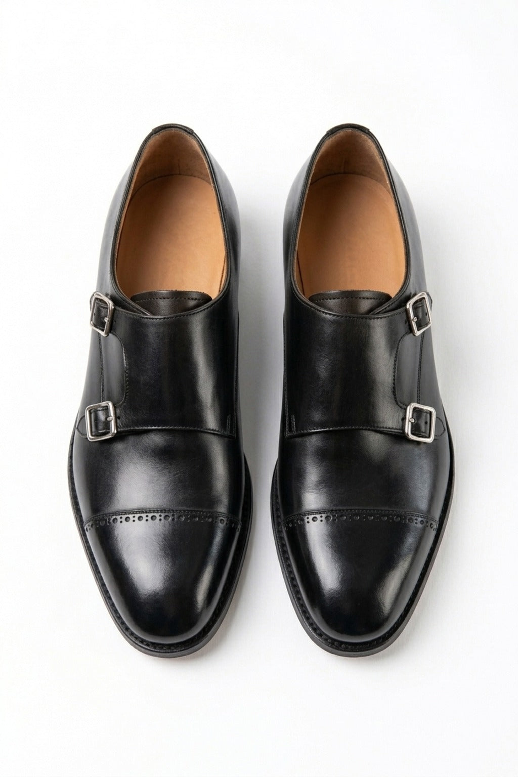 The Friar Black Leather Double Monk pair on white, top-down view of the silver buckles and punched cap toe