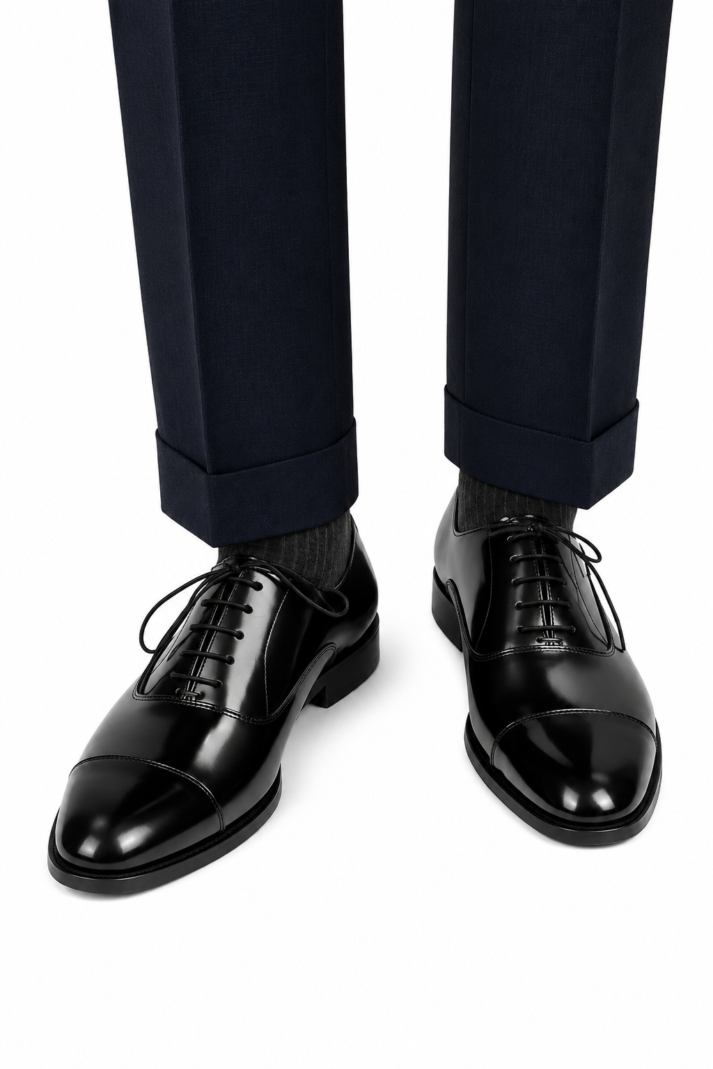 The Haider Black Patent Leather Oxford worn with navy turn-up trousers, front view